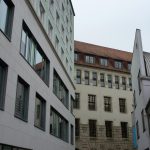 Neubau vor historischem Hintergrund